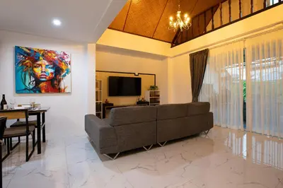a living room with a couch and a television at Villa Homey in Patong Beach