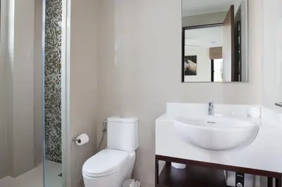 a bathroom with a toilet and a sink and a mirror at Modern 5-Bedroom Pool Villa in Laguna Phuket