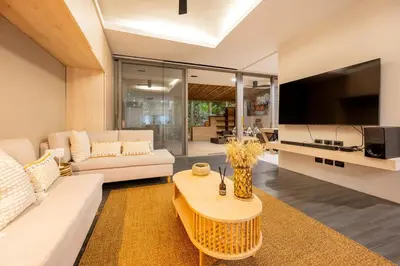 a living room with a white couch and a tv at Balinese Apartment Kamala beach near Cafe del Mar in Kamala Beach