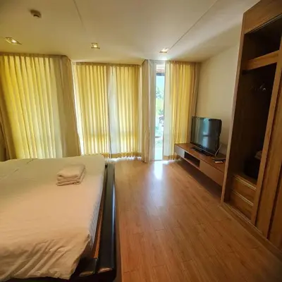 a hotel room with a bed and a television at Luxury 2 Bedroom Duplex with Private Pool- Privilege Residence Patong in Patong Beach