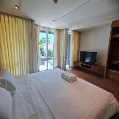 a bedroom with a large white bed and a television at Luxury 2 Bedroom Duplex with Private Pool- Privilege Residence Patong in Patong Beach