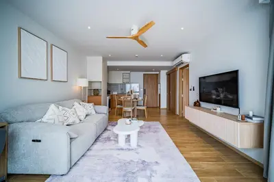a living room with a couch and a table at Beachside Residences by NLA in Bang Tao Beach