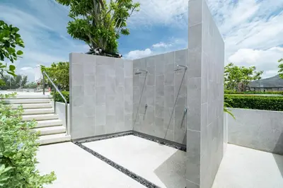 a stone shower in a bathroom with stairs at Beachside Residences by NLA in Bang Tao Beach