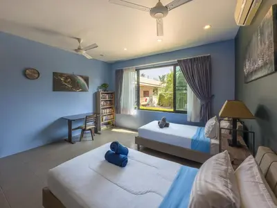 a bedroom with two beds and a desk and a window at Villa Intira 5 bedrooms with 12m private pool and garden in Rawai Beach