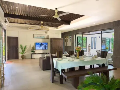 a dining room and living room with a table and chairs at Villa Intira 5 bedrooms with 12m private pool and garden in Rawai Beach