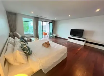 a bedroom with a white bed and a flat screen tv at Thebirdhouse Patong Phuket201 in Patong Beach
