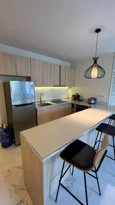 a kitchen with a counter and a refrigerator and chairs at New Years Super Fancy 2br Villa near Cafe Del Mar in Kamala Beach