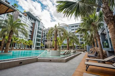 a pool at a hotel with palm trees and chairs at C225 City Gate Kamala Great facilities 600m to beach in Kamala Beach