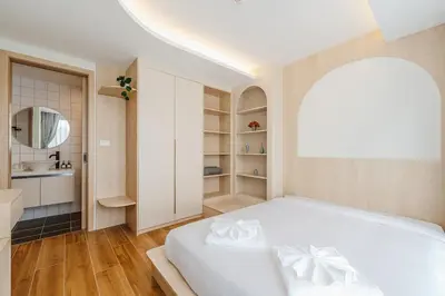 a bedroom with a white bed and a bathroom at C169 Part of the famous Fantasea Kamala in Kamala Beach