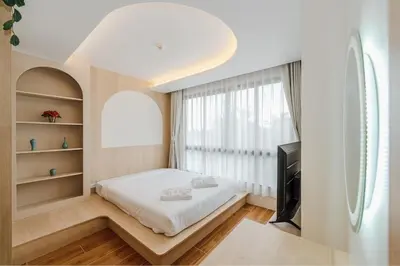 a bedroom with a bed and a tv and a window at C169 Part of the famous Fantasea Kamala in Kamala Beach