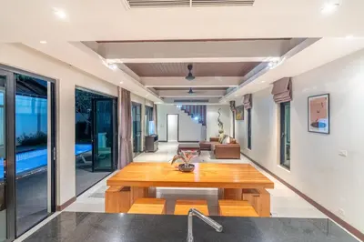 a living room with a wooden table at Pasak Villa in Laguna Phuket