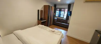 a small bedroom with a bed and a couch at Tiger Nanai guest house in Patong Beach