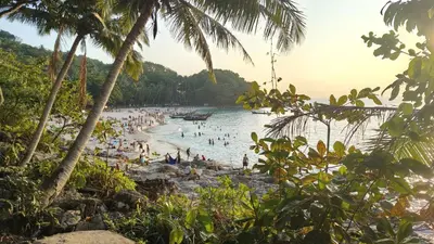 a group of people in the water at a beach at Tiger Nanai guest house in Patong Beach