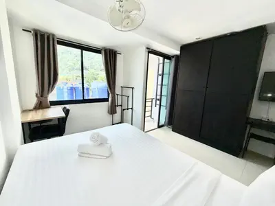 a bedroom with a white bed and a large window at Patong Easy Life 7 in Patong Beach