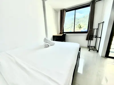 a white bed in a room with a window at Patong Easy Life 7 in Patong Beach