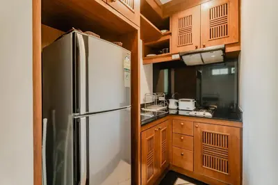 a kitchen with a stainless steel refrigerator and wooden cabinets at Rose Pool Villa The perfect private oasis in Rawai Beach