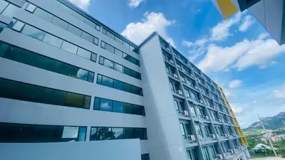 a tall white building with a blue sky in the background at Utopia Central Kathu Condo in Phuket Town