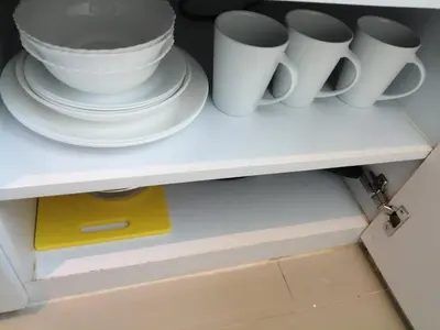 a shelf with white cups and plates on it at Utopia Central Kathu Condo in Phuket Town