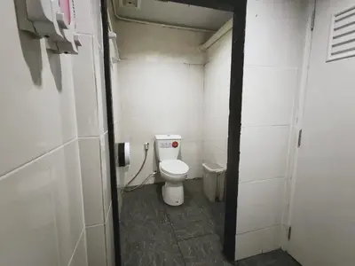 a small bathroom with a toilet in a stall at Babyshark Hostel - Loh Dalum Bay in Phi Phi Don