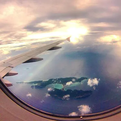 a view of the wing of an airplane flying over the ocean at Babyshark Hostel - Loh Dalum Bay in Phi Phi Don