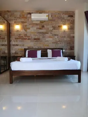 a large bed in a room with a brick wall at OMG !! Amazing Sea Views !! Stunning Sunsets !! Khao Thong Krabi Thailand in Ban Khao Thong