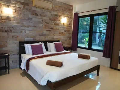 a bedroom with a large bed and a brick wall at OMG !! Amazing Sea Views !! Stunning Sunsets !! Khao Thong Krabi Thailand in Ban Khao Thong