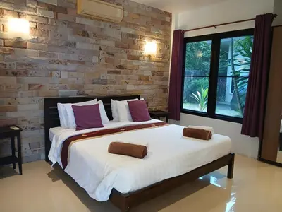 a bedroom with a large bed and a brick wall at OMG !! Amazing Sea Views !! Stunning Sunsets !! Khao Thong Krabi Thailand in Ban Khao Thong