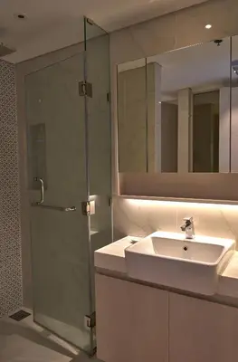 a bathroom with a sink and a glass shower at Cassia Residences 1BDR Lake view in Laguna Phuket