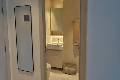 a bathroom with a sink and a toilet and a mirror at Cassia Residences 1BDR Lake view in Laguna Phuket