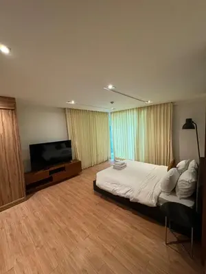 a bedroom with a bed and a flat screen tv at Privilège résidence patong in Patong Beach