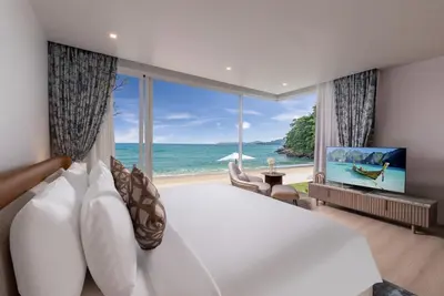 a bedroom with a large bed with a view of the ocean at Villa AMANN in Phuket Town