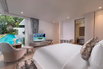 a bedroom with a large white bed and a pool at Villa AMANN in Phuket Town
