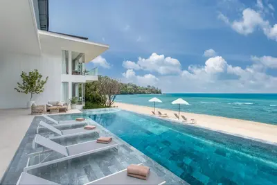 a villa with a swimming pool next to a beach at Villa AMANN in Phuket Town