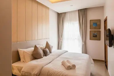 a bedroom with a large bed with two towels on it at Karon rooftop pool condo in Karon Beach