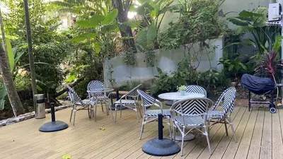 a group of chairs and tables on a wooden deck at Karon rooftop pool condo in Karon Beach