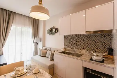 a kitchen and living room with a couch and a table at Karon rooftop pool condo in Karon Beach