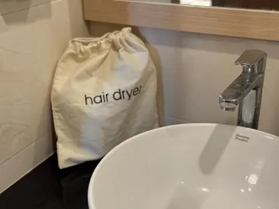 a bathroom with a white sink and a bag with half dive at Karon rooftop pool condo in Karon Beach