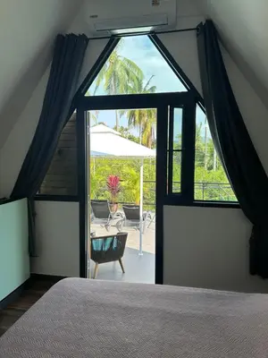 a bedroom with a bed and a view of a patio at Rawai Beach studio in Nai Harn Beach