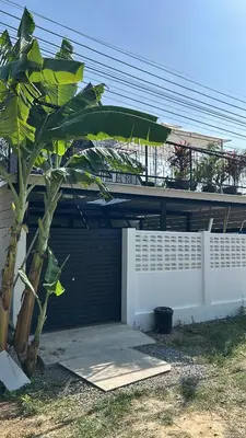 a tree in front of a house with a fence at Rawai Beach studio in Nai Harn Beach
