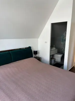 a bedroom with a bed and a bathroom with a sink at Rawai Beach studio in Nai Harn Beach