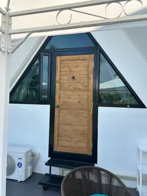 a wooden door in the middle of a room at Rawai Beach studio in Nai Harn Beach