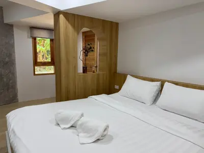a bedroom with a white bed with white pillows at Cozy room Maikhao Phuket in Ban Ao Tu Khun