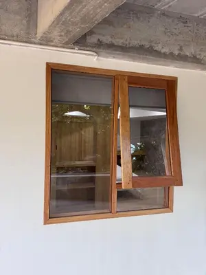 a wooden window on a white wall at Cozy room Maikhao Phuket in Ban Ao Tu Khun