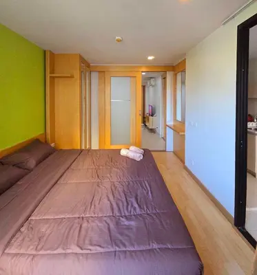 a large bed in a room with green walls at The feeltrue phuket CK in Phuket Town