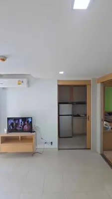 a living room with a tv and a kitchen at The feeltrue phuket CK in Phuket Town