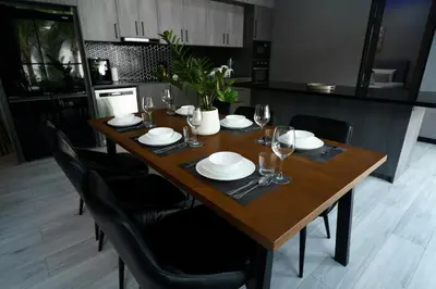 a wooden table with chairs and plates and wine glasses at Diamond 2 Villa by G Estate Phuket in Ban Saiyuan (1)