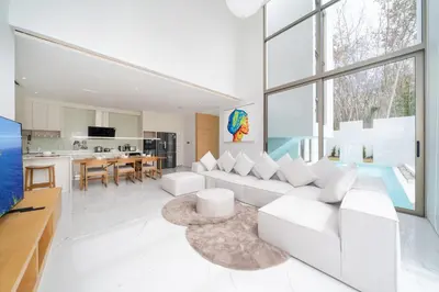 a living room with a white couch and a kitchen at Brand New & Modern Luxury 4BR Pool Villa in Residence Lux Pride 2 V12 in Bang Tao Beach