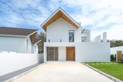 a white house with a brown roof at Brand New & Modern Luxury 4BR Pool Villa in Residence Lux Pride 2 V12 in Bang Tao Beach