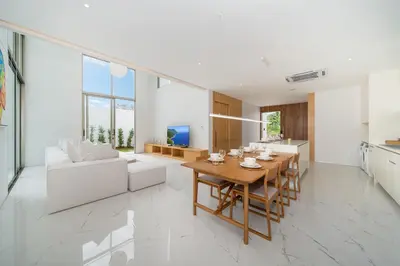 a kitchen and living room with a wooden table and chairs at Brand New & Modern Luxury 4BR Pool Villa in Residence Lux Pride 2 V12 in Bang Tao Beach