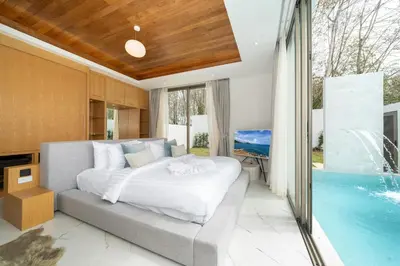 a bedroom with a bed and a swimming pool at Brand New & Modern Luxury 4BR Pool Villa in Residence Lux Pride 2 V12 in Bang Tao Beach